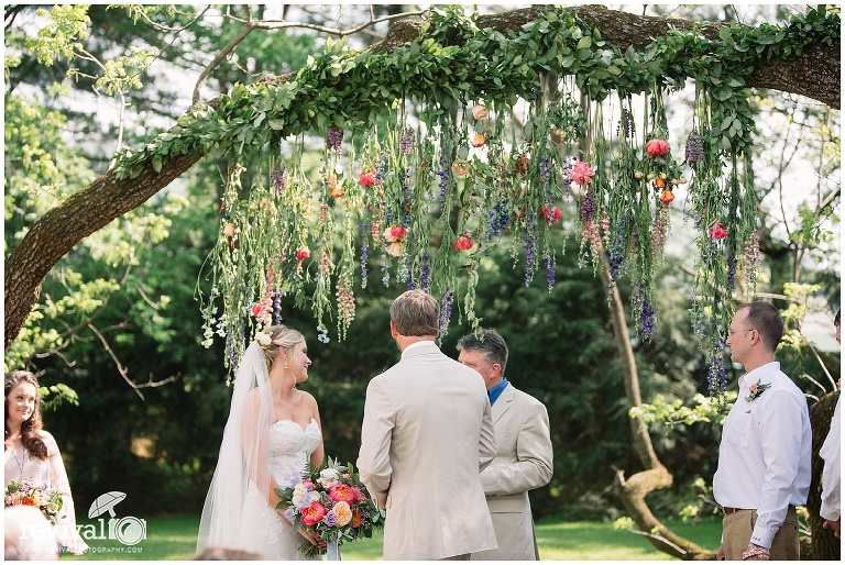 Ceremony under tree trimmed with flowers